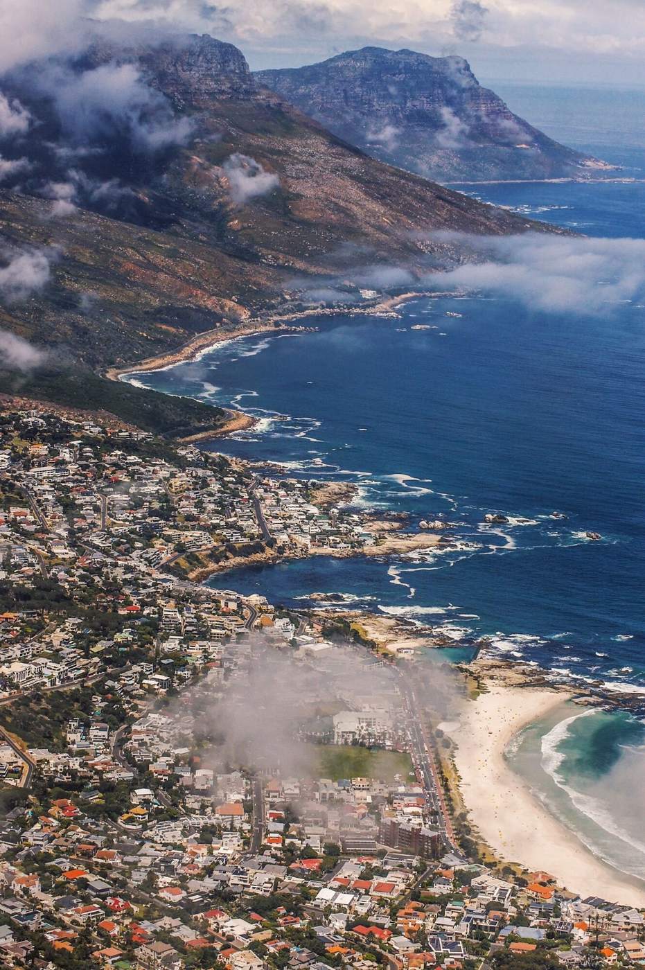 Camps Bay and the Atlantic coast from above, with clouds drifting over the Twelve Apostles