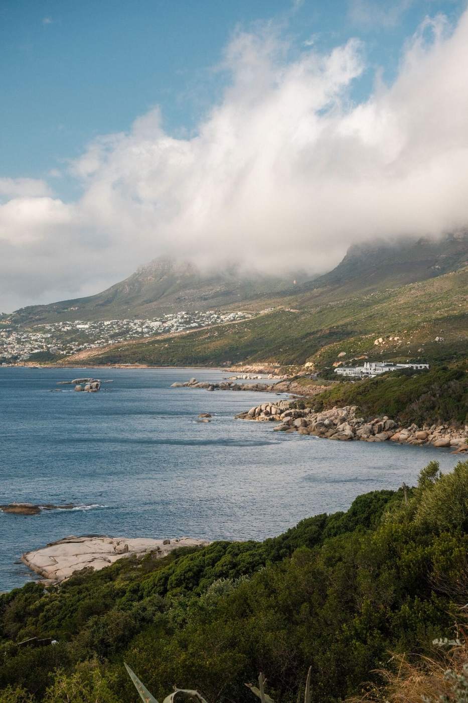 The rocky Atlantic coast road below the Twelve Apostles, with cloud spilling over the mountains